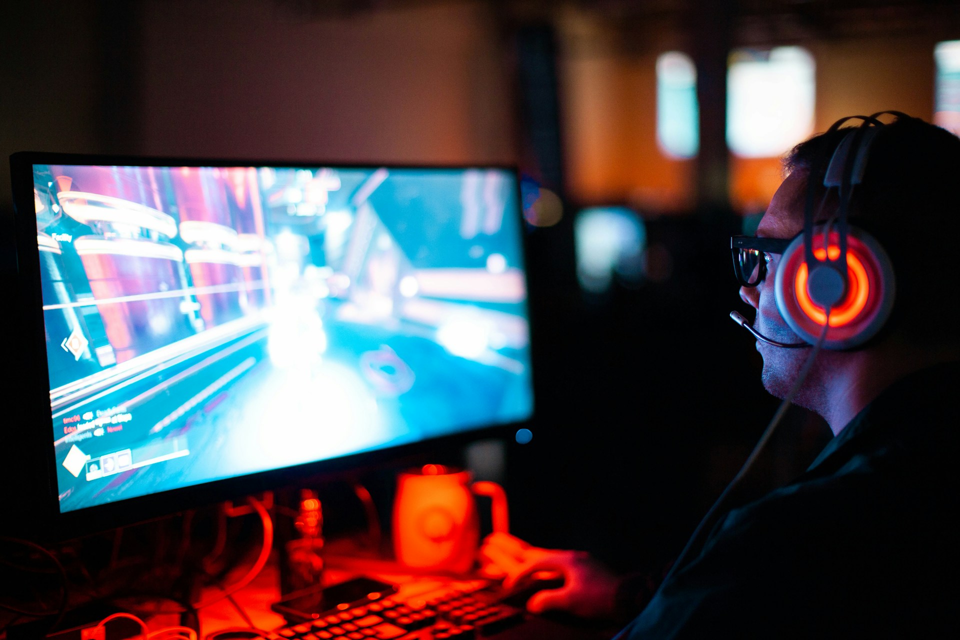 a man playing Splitgate 2 on his PC in a dark room with RGB lights