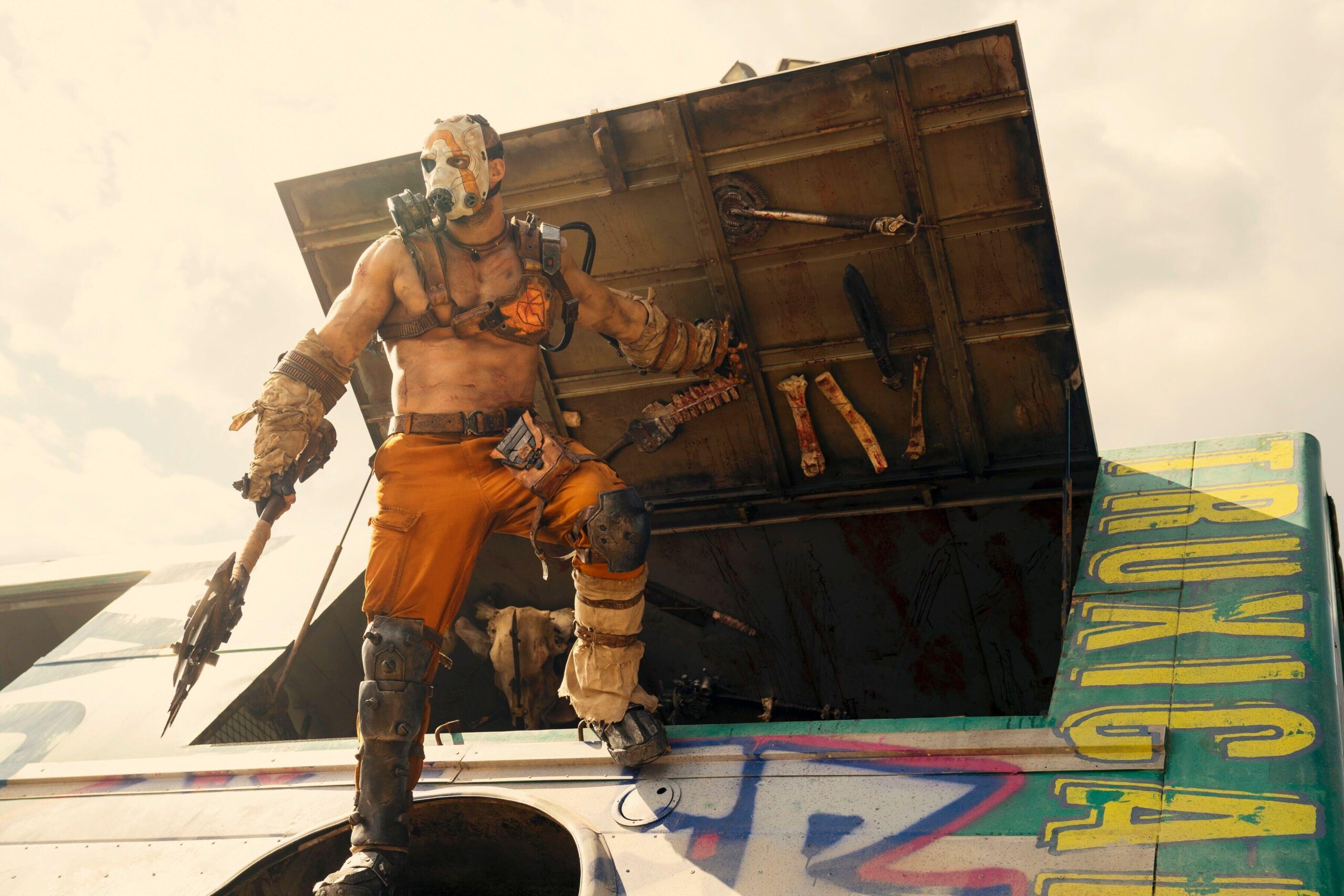 a Psycho, character from the Borderlands 4 and other franchises, standing on a moving truck loaded with weapons